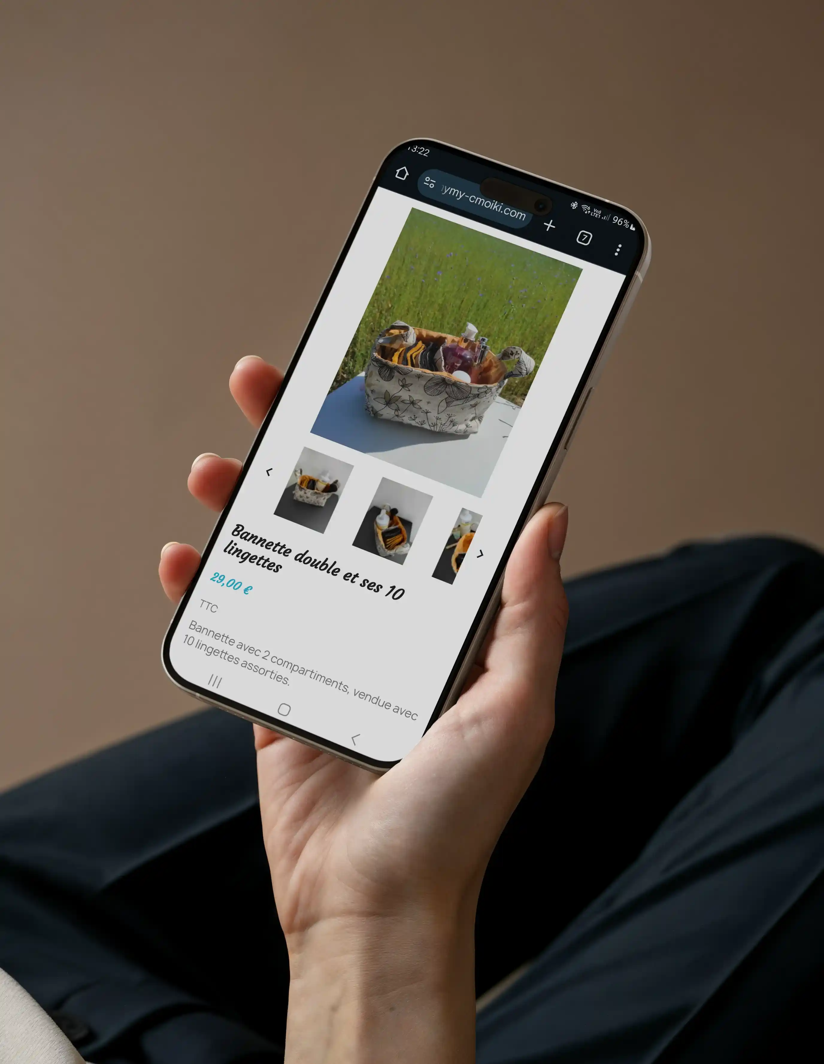 Photo d'un téléphone tenu par une personne et affichant la page produit : 'bannette double et ses 10 lingettes' au prix de 29,00 € sur le site de mymy-cmoiki.