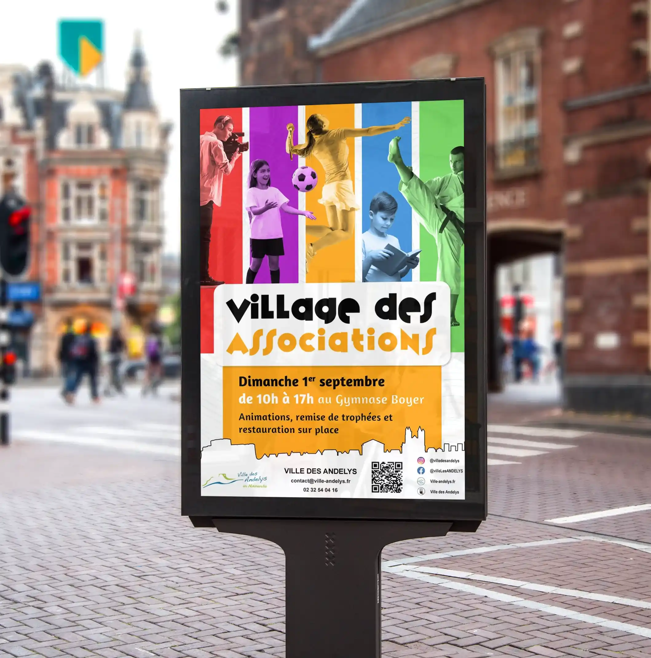 Photo d'une affiche pour l'événement : 'Le village des associations' dans une rue passante.